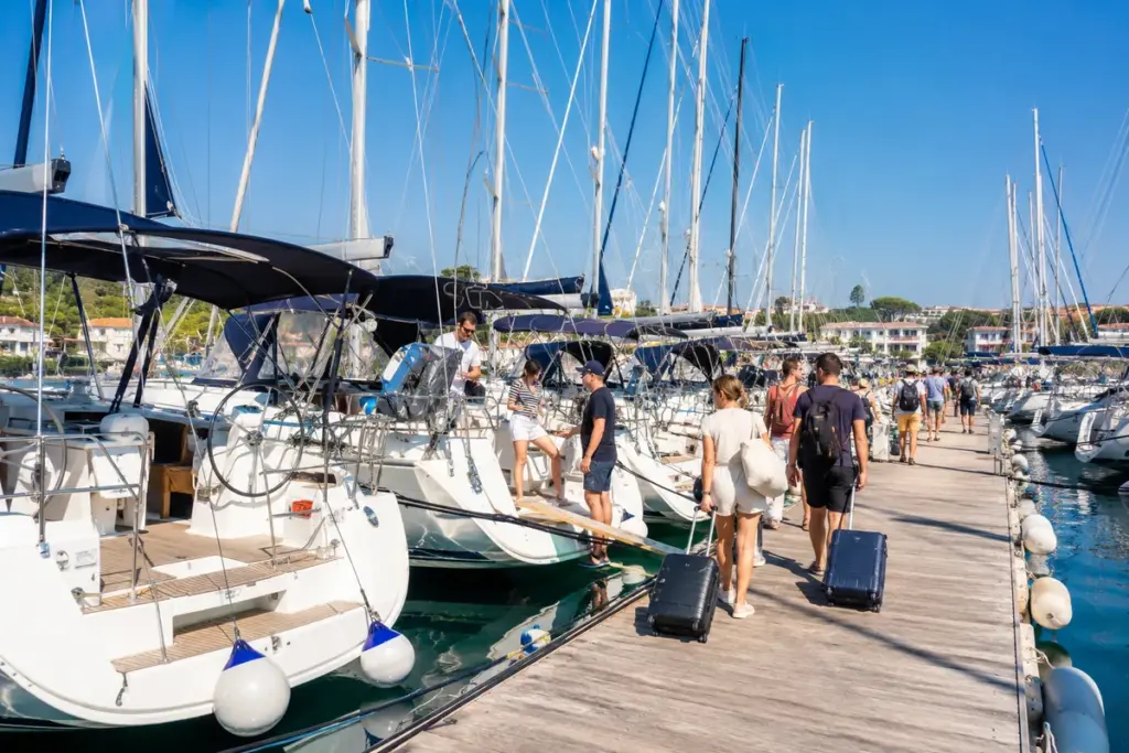 Belebte Marina am Samstag mit vielen weissen Charteryachten und Gepaeck am Steg