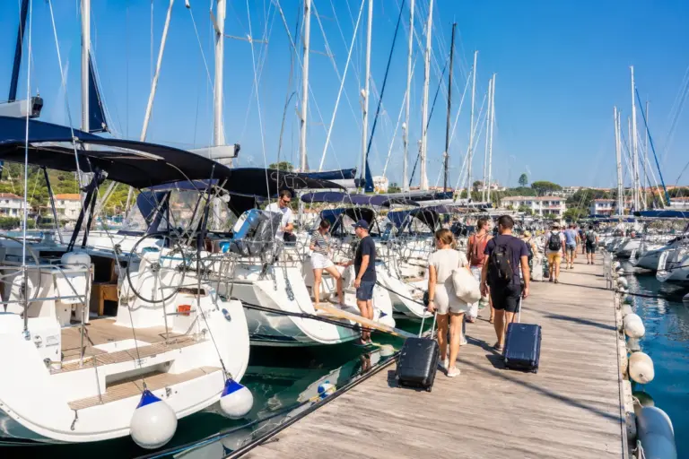 Belebte Marina am Samstag mit vielen weissen Charteryachten und Gepaeck am Steg