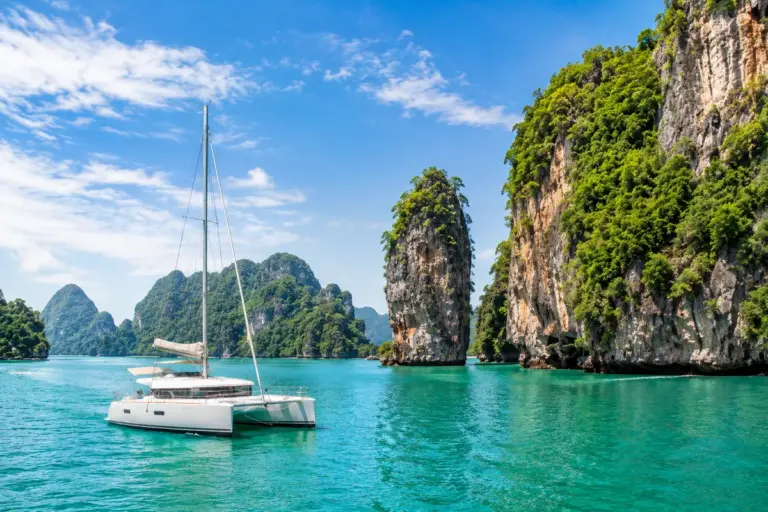 Katamaran zwischen Kalksteinfelsen der Andamanensee bei Phuket in Thailand