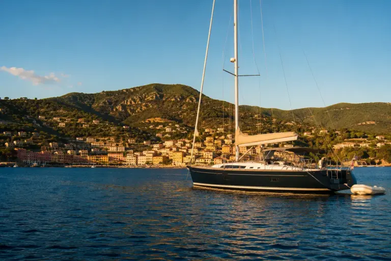 Segelyacht vor der Kueste von Elba in der Toskana im goldenen Licht