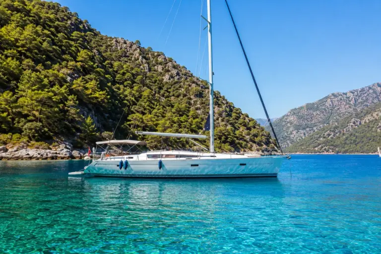 Segelyacht in einer geschuetzten Tuerkisbucht mit Pinienbergen an der tuerkischen Tuerkiskueste
